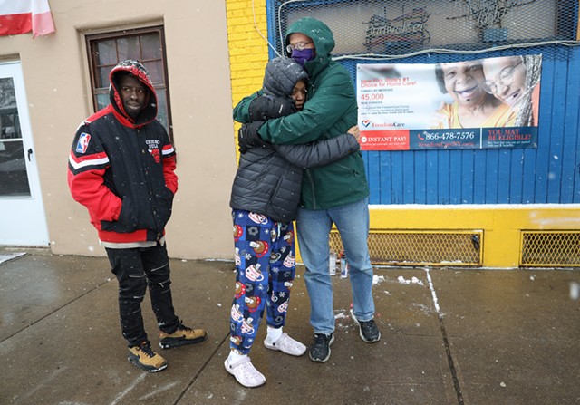 Ed Knauf hugs Monique Bunton, the mother of Julius Greer Jr., with the boy's father, Julius Greer Sr. at left. “I can’t believe somebody really did this to my baby because he didn’t deserve this,” she said. “He was just at the wrong place at the wrong time.” - PHOTO BY MAX SCHULTE