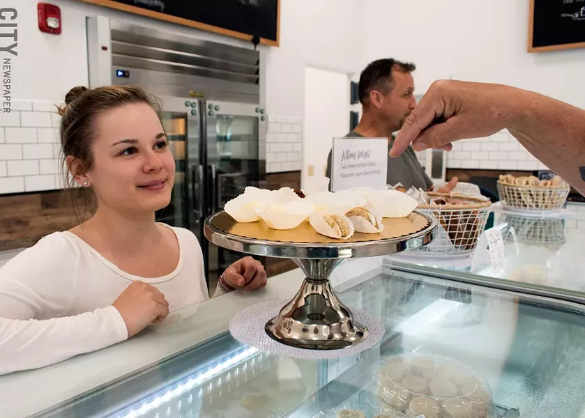 Hannah Perry guides a customer through the Cheesy Eddie's sample platter, while owner John Baker chats with customers in their new Henrietta location. - PHOTO BY RENÉE HEININGER