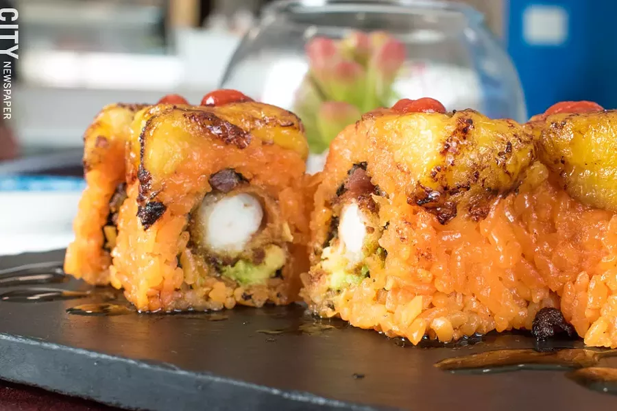 The Merengue Roll features beer-battered shrimp, bacon, Sriracha, and avocado, and is topped with sweet plátanos and Stingray Sauce. - PHOTO BY JACOB WALSH