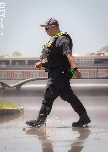 An emergency worker walks through flood waters. - PHOTO BY RYAN WILLIAMSON