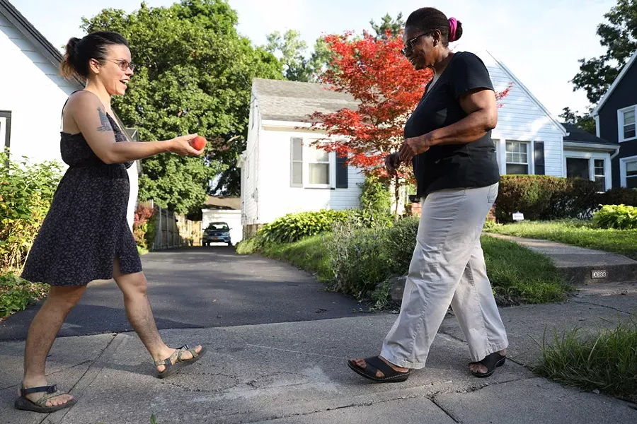 Lindsey Downey brings a peach to her neighbor, Janet Williams. - PHOTO BY MAX SCHULTE