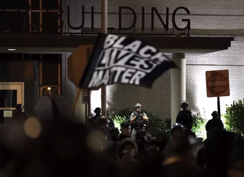 Rochester police in riot gear keep an eye on protesters outside the Public Safety Building on Sept. 6, 2020. - PHOTO BY MAX SCHULTE