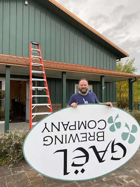 Big aLICe co-owner Kyle Hurst takes down the sign at the former GAEL Brewing Company in Geneva. - PROVIDED PHOTO