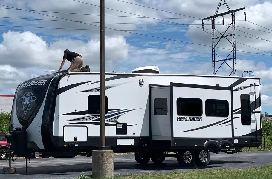Tim Clark works on the roof of the RV. - PHOTO PROVIDED BY COLLINS AND CLARK