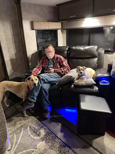 Tim Clark relaxes in the RV with the dogs. - PHOTO PROVIDED BY COLLINS AND CLARK