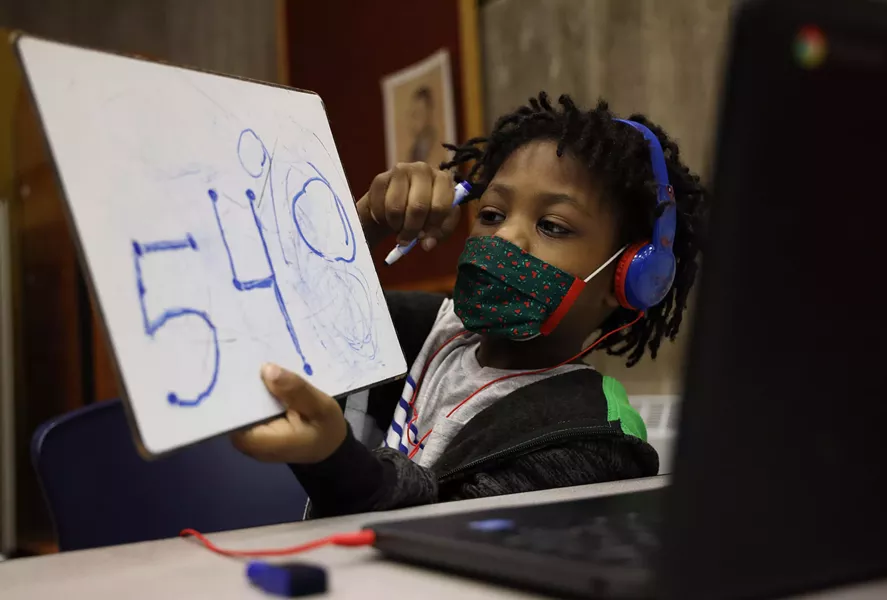 Kaleb Wilcoxson, a kindergartner, shows his work to his virtual class on a whiteboard. - PHOTO BY MAX SCHULTE / WXXI NEWS