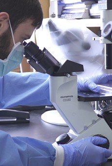A University of Rochester lab worker examines samples.