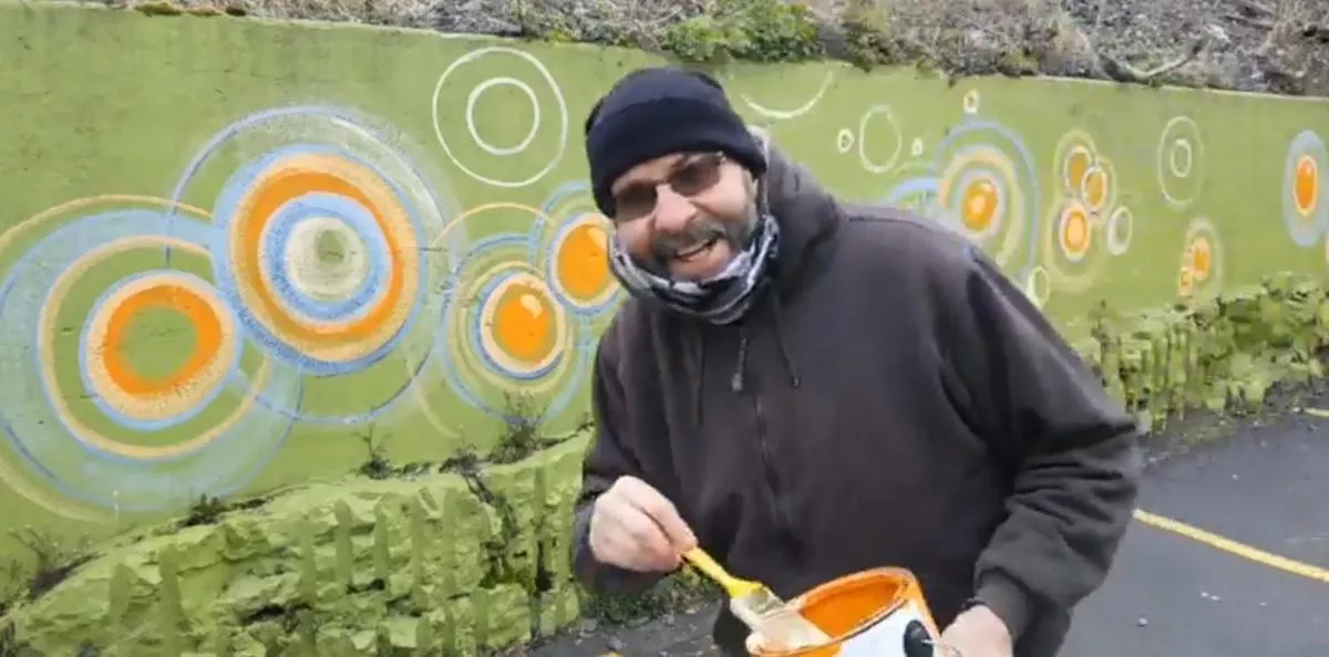 In a Facebook video, Rochester artist Mark Groaning paints a parking lot retaining wall at Artisan Works. - FACEBOOK SCREENSHOT
