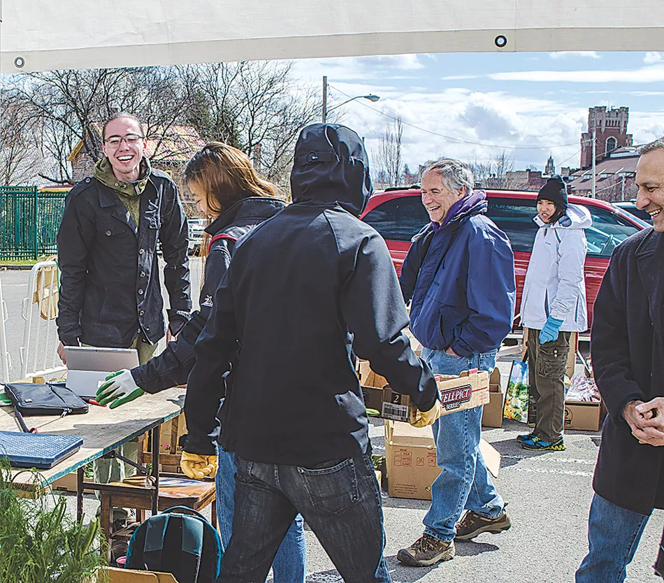 FCP Acting Director Evan Zachary (left) with volunteers at the Public Market. - PHOTO COURTESY FLOWER CITY PICKERS