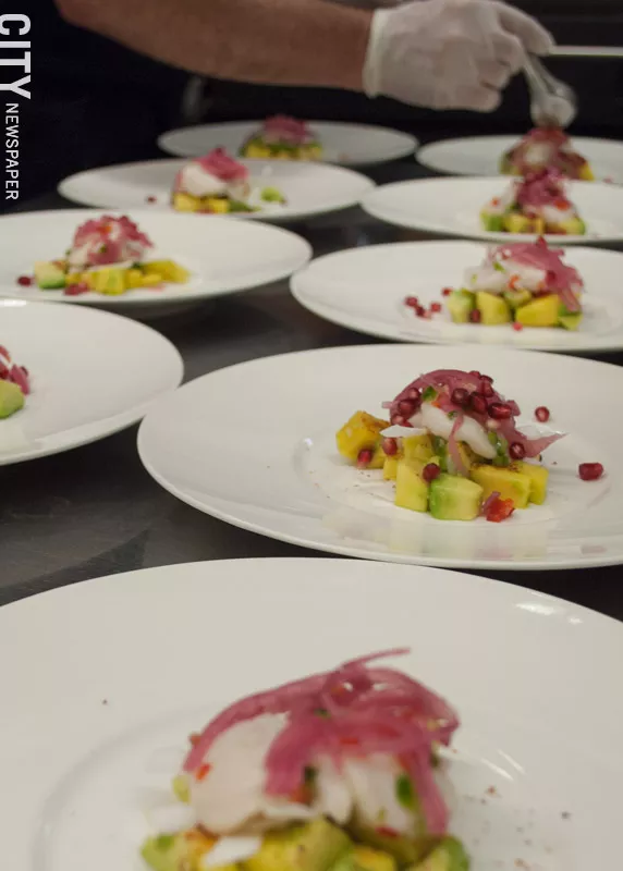 The second course of the Dia de los Muertos dinner at Atlas Eats is ceviche with lime scallops atop a bed of chopped avocado, mango, and slices of fresh coconut. - PHOTO BY REBECCA RAFFERTY