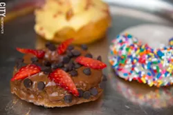 Vanilla rainbow, chocolate covered strawberry and peaches, apricot, and cream donuts at The Red Fern. - PHOTO BY THOMAS J. DOOLEY