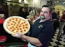 Steve Florio shows off a freshly made New Jersey-style pepperoni pizza at his family's Linclon Heights eatery.