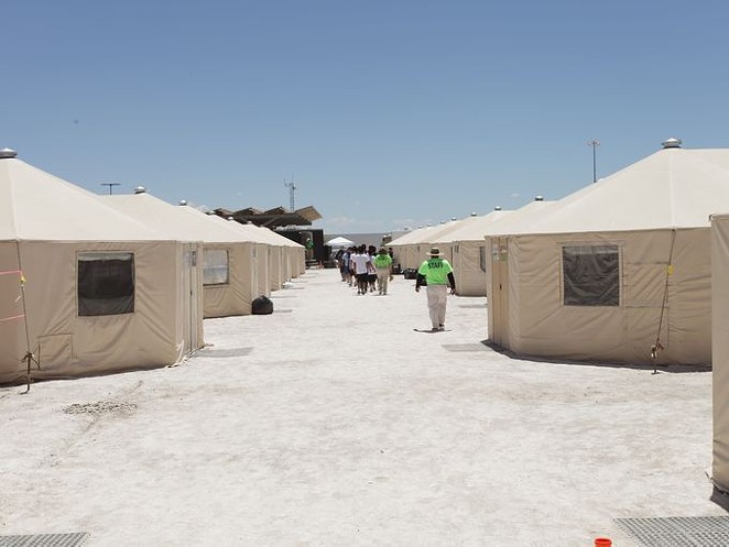 Staff and detainees walk between the tents inside the Tornillo, Texas, detention center. - U.S. DEPARTMENT OF HEALTH AND HUMAN SERVICES