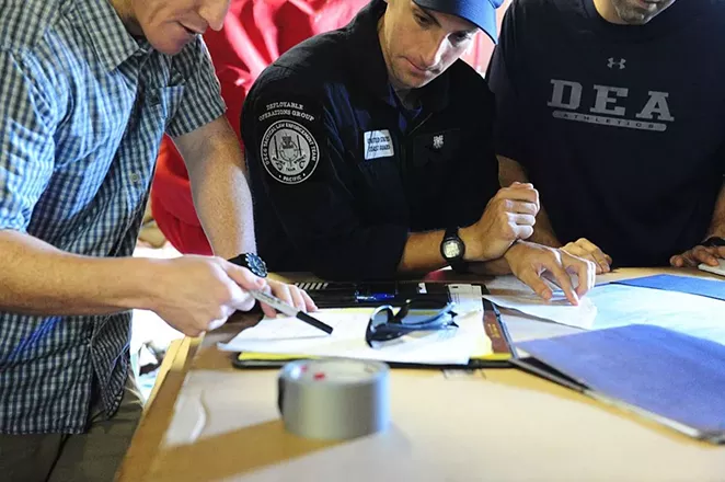 A Coast Guard official transfers chain of custody of seized narcotics to DEA agents. - LAUREN JORGENSEN