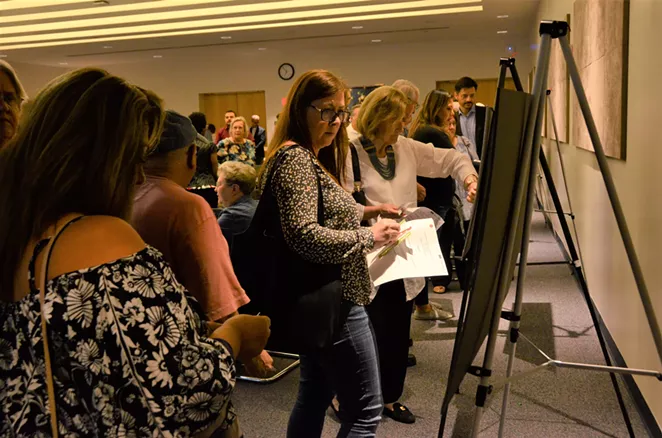 Residents look at Maverick Plaza plans and renderings during Tuesday night's meeting. - LEA THOMPSON