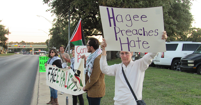 Protestors hold up signs and banners outside of Pastor John Hagee's Cornerstone Church. - SANFORD NOWLIN
