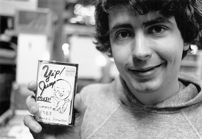 Daniel Johnston shows off one of his self-released tapes. - COURTESY OF DANIEL JOHNSTON