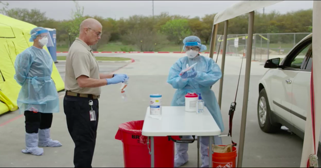 Emergency workers deal with a sample at a drive-through testing unit in a State of Texas-produced video. - CITY OF SAN ANTONIO
