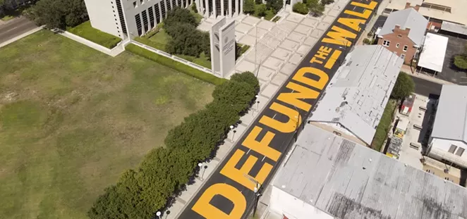 Laredo's "Defund the Wall" mural decorates the street in front of the border city's federal courthouse. - COURTESY PHOTO / JULIAN ROTNOFSKY