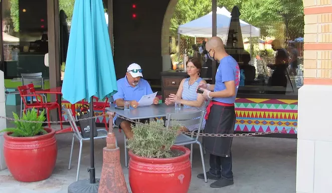 A server at a restaurant at the Pearl development takes an order from diners earlier this summer. - SANFORD NOWLIN