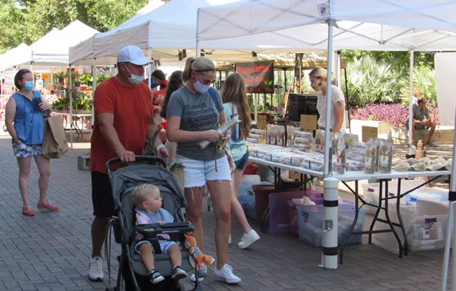 Visitors to the Pearl's weekend farmer's market in San Antonio wear masks as they stroll among the vendors. - SANFORD NOWLIN