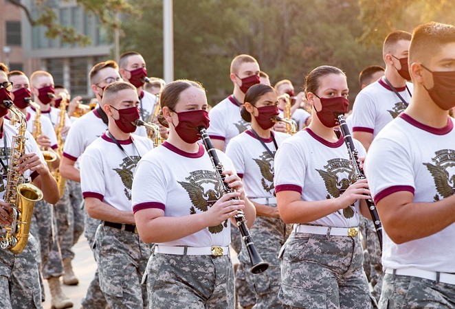 Members of the Aggie Band march through the Texas A&M campus while wearing masks. - TWITTER / @AGGIECORPS