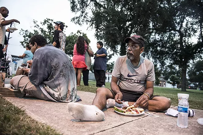 One of The Chow Train's diners eats at Maverick Park. - CARLOS SANCHEZ