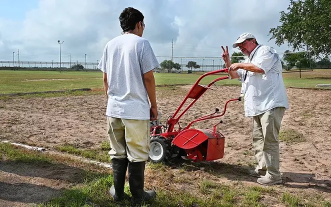 A horticulture teacher shows a youth at a TJJD facility how to safety start a garden tiller. - COURTESY PHOTO / TJJD