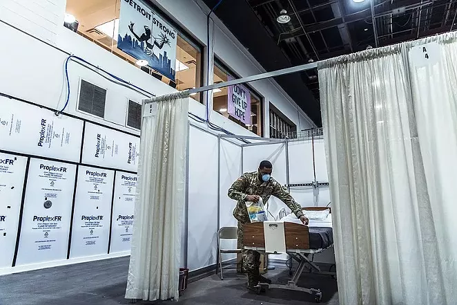 A solider helps prepare a room in a temporary hospital facility in Detroit to handle overflow COVID-19 patients. - WIKIMEDIA COMMONS / NATIONAL GUARD