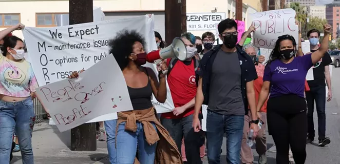 Protestors march down South Flores Street on Saturday toward the Steel House Lofts, where SAHA CEO David Nisivoccia lives. - BEN OLIVO / SA HERON