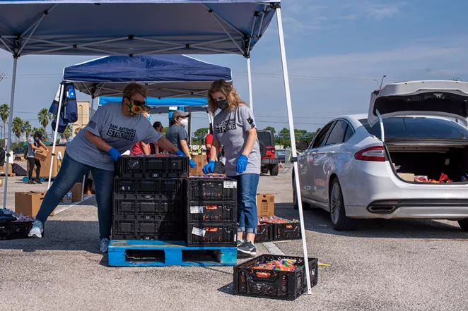 Volunteers unload pallets at a recent San Antonio Food Bank distribution. - TWITTER / @SAFOODBANK