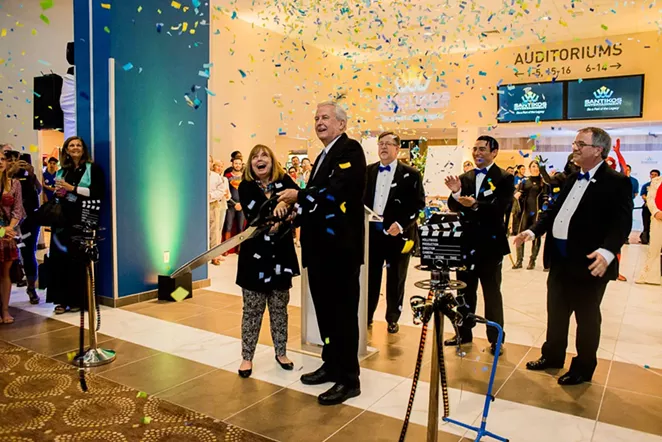 Dennis Noll, San Antonio Area Foundation CEO, and his wife Marty cut the film ribbon to mark the opening of Santikos Entertainment's newest movie theater Casa Blanca. Behind them from left to right: Santikos Entertainment CEO David Holmes, Casa Blanca general manager Roger Treviño and Santikos president Arthur Seago. - COURTESY
