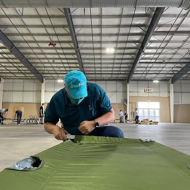A Catholic Charities volunteer helps assemble cots before unaccompanied minors arrived at the shelter. - INSTAGRAM / CATHOLIC CHARITIES OF SAN ANTONIO