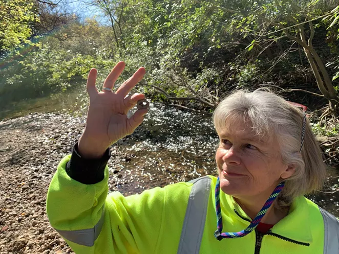 Salado Creek Foundation chief Sue Calberg examines a find along the greenway trail. - BILL BAIRD