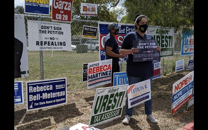 Opponents of Fix SAPD's petition drive hold up signs at a polling site where volunteers collected signatures last fall. - COURTESY PHOTO / FIX SAPD