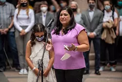 Lisa Stanton, with her daughter Maya, spoke at an event held by Equality Texas at the state Capitol on April 14. - TEXAS TRIBUNE / SERGIO FLORES