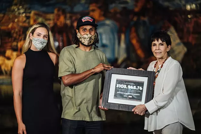 Spurs guard Patty Mills presents a $104,000 donation to Family Violence Prevention Services last year as part of a fundraiser he organized. - TWITTER / PATTY_MILLS