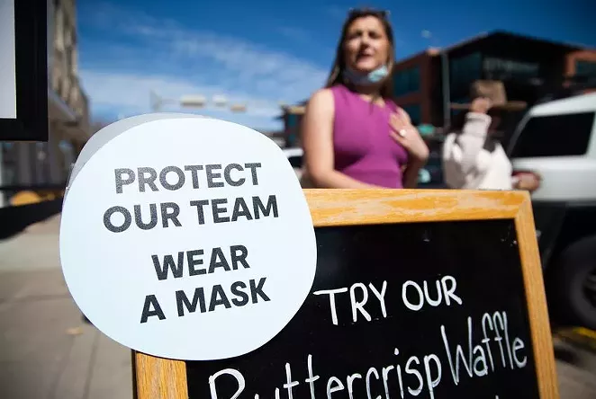 A sign in South Austin asks customers to wear a mask inside a business on March 3, 2021. - TEXAS TRIBUNE / EVAN L'ROY