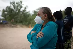 A Venezuelan migrant watches as her husband is arrested by a Texas Department of Public Safety trooper in Del Rio last week. - TEXAS TRIBUNE / MIGUEL GUTIERREZ JR.