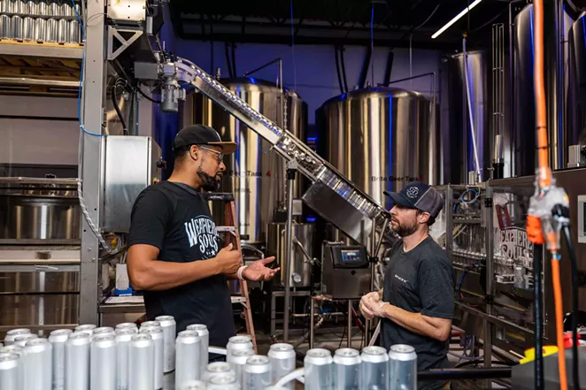 Baskerville speaks with a Weathered Souls employee at the Northeast San Antonio brewery. - JAIME MONZON