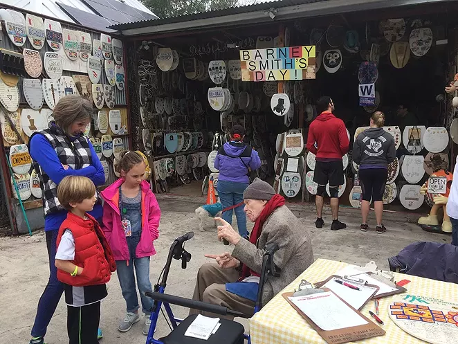 BARNEY SMITH WITH RECENT VISITORS TO HIS TOILET SEAT ART MUSEUM IN ALAMO HEIGHTS
