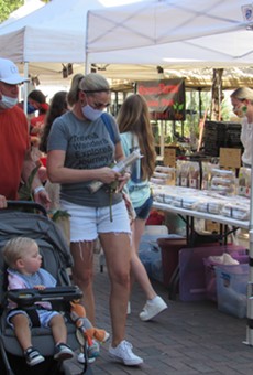 Visitors to the Pearl's weekend farmer's market in San Antonio wear masks as they stroll among the vendors.