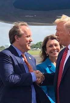 Texas AG Ken Paxton (center) meets President Donald Trump on the Tarmac during a 2019 presidential visit to Houston.