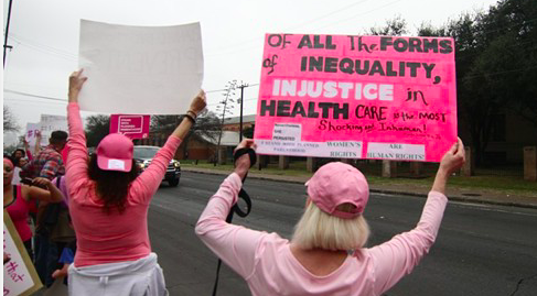 Protesters hold up signs at a pro-Planned Parenthood rally in San Antonio. - MICHAEL BARAJAS