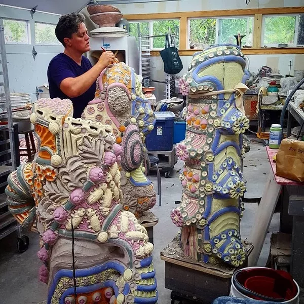 Diana Kersey, working in her home studio, brushes paint onto the dry, unfired sculptures destined for VIA Five Points. - COURTESY