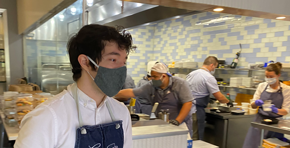 A masked server carries out an order at San Antonio restaurant Clementine. - SANFORD NOWLIN