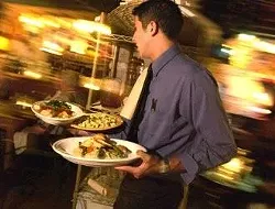 Waiter Remmy Castillo rushes out an order on a busy Thursday evening at Dolores del Rio.