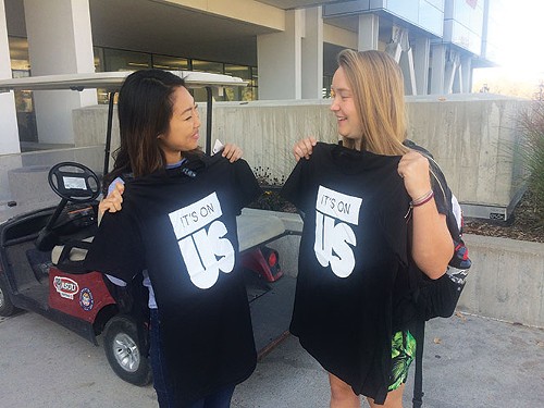 U students Katie Kume and Lauren Radke compare T-shirts they received for pledging to intervene in situations they believe could lead to sexual assault on Oct. 26. - ANNIE KNOX