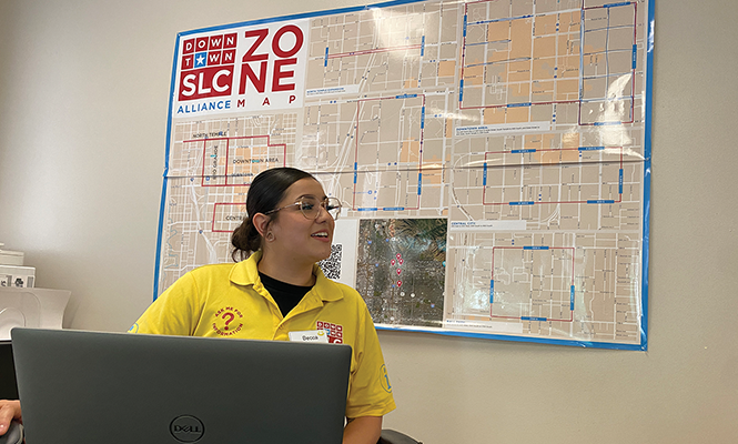 Becca Rieger prepares for a shift in front of a map of service areas. - BENJAMIN WOOD
