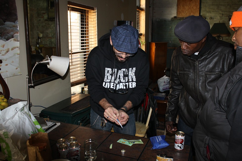 Tino Fuentes, left, checks for fentanyl contamination in heroin in a Baltimore warehouse apartment as William Miller looks on. - BAYNARD WOODS